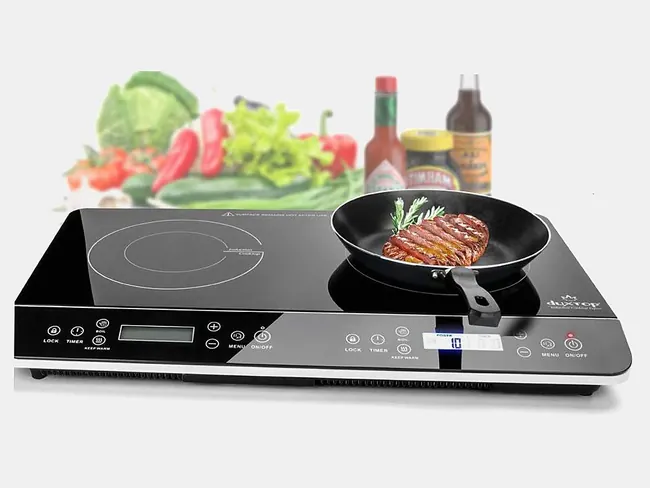 A double Duxtop induction cooktop with a steak searing in a pan on one zone